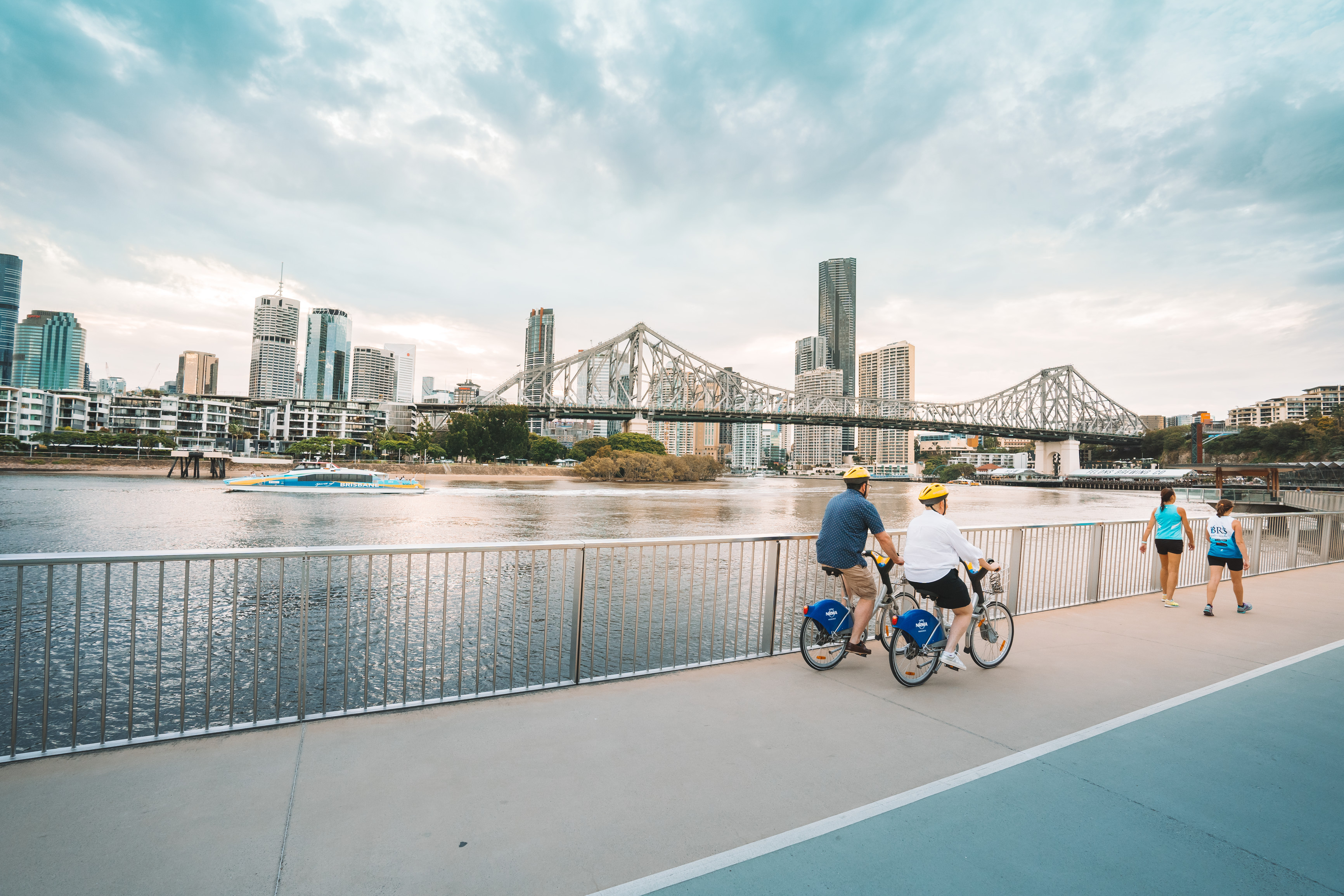 Couple cycling along the floating river walkway