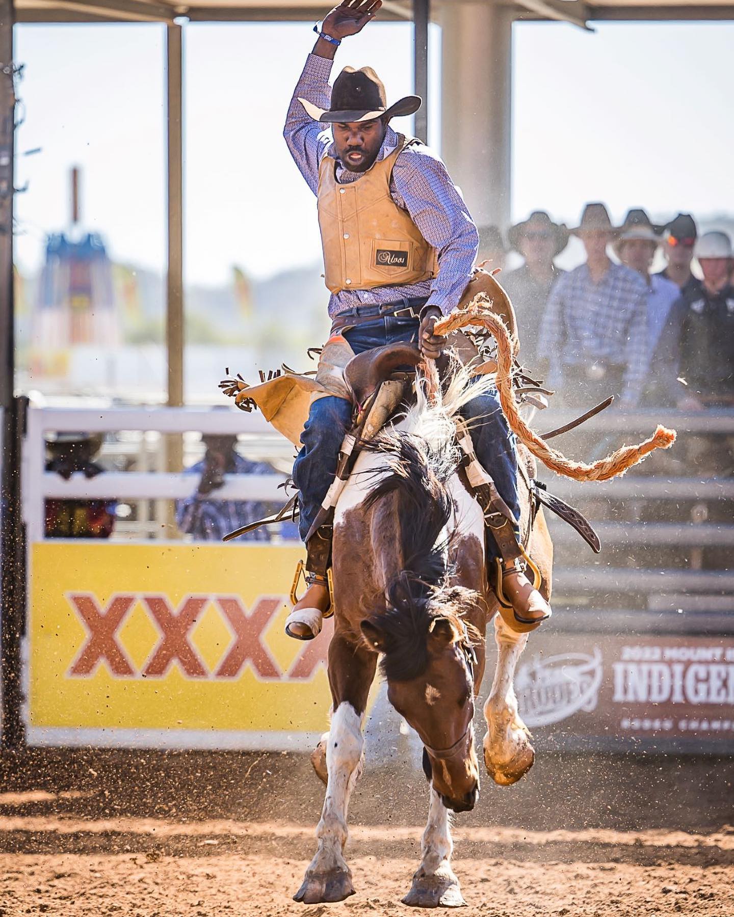 Indigenous rodeo athlete rides bronco during Mount Isa Mines Indigenous Rodeo Championships, Outback Queensland