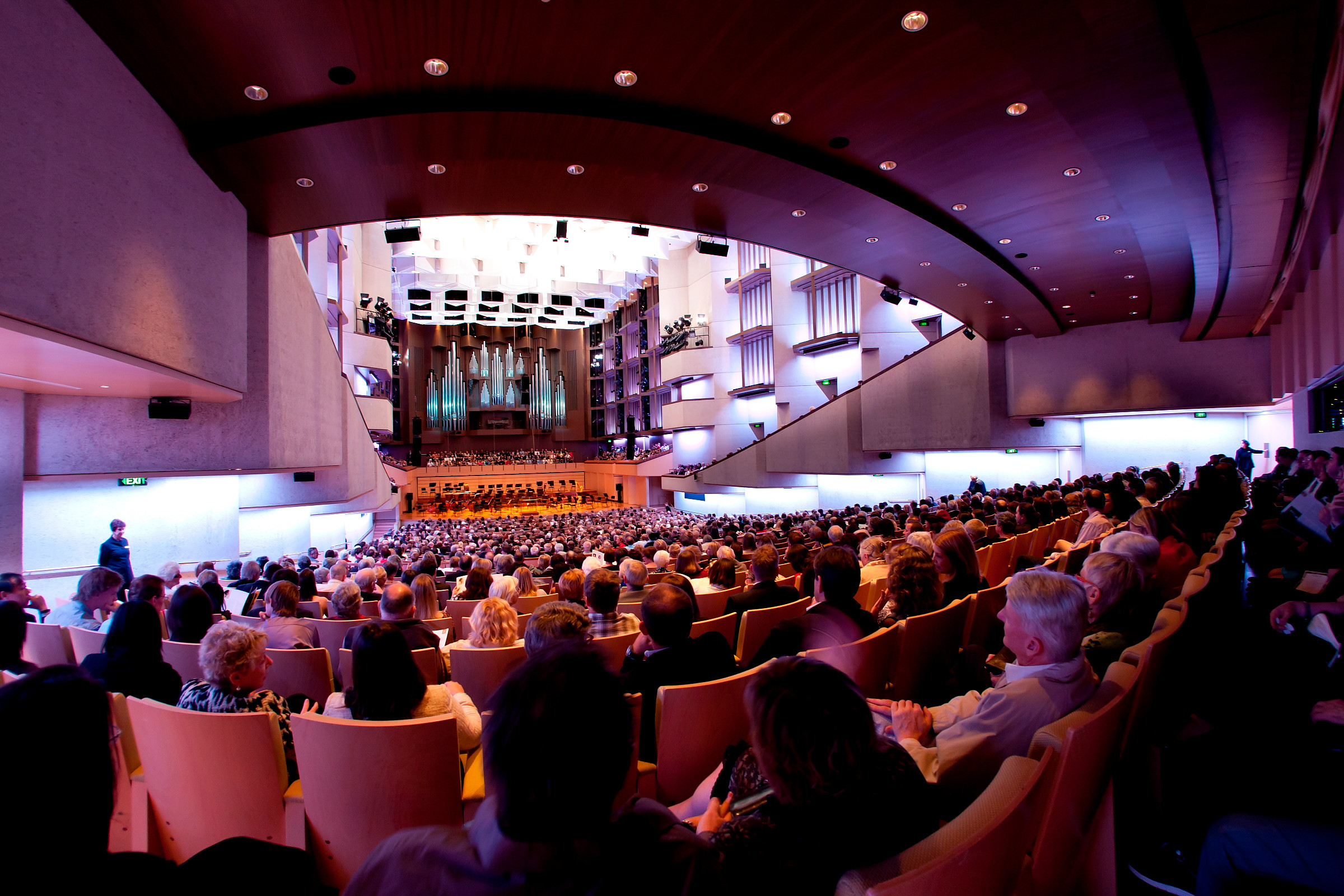 A large audience sitting in an auditorium is watching a performance at the Queensland Performing Arts Centre.